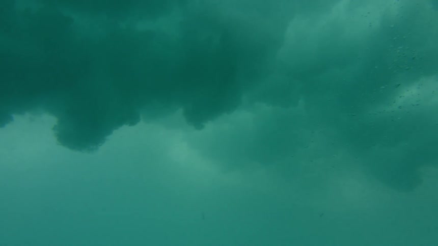 Waves roll and crash on the surface from underwater
