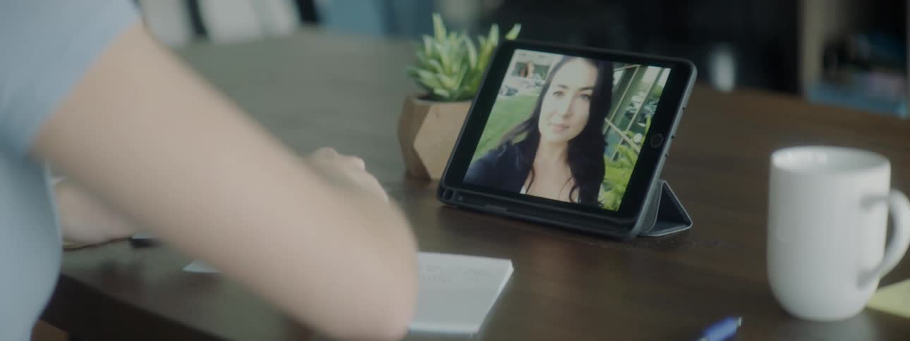 Woman using tablet for video call while working