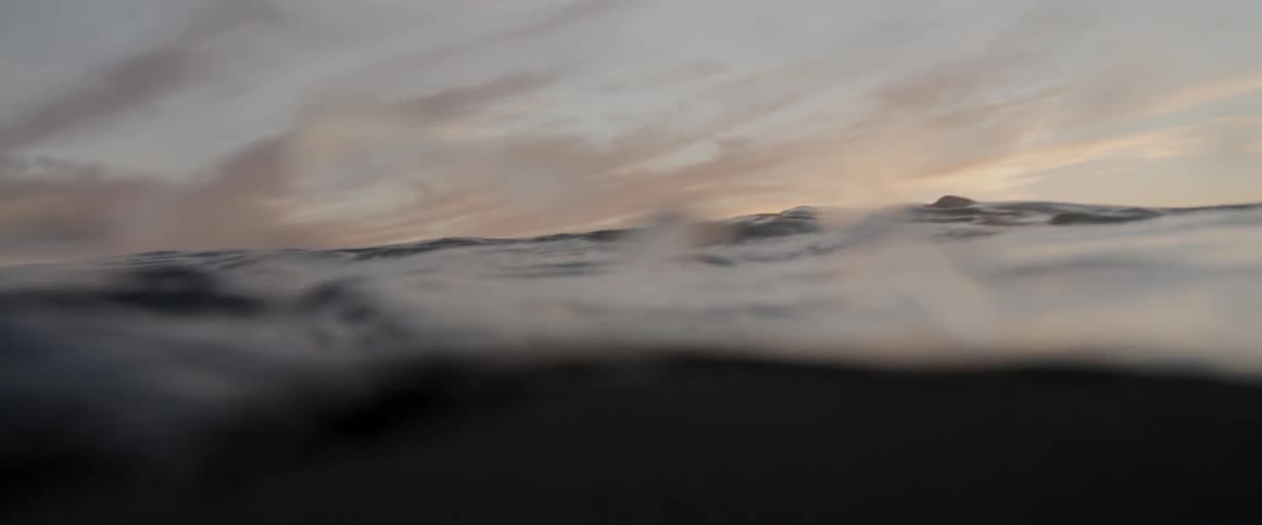 Man surfing in the ocean at dawn
