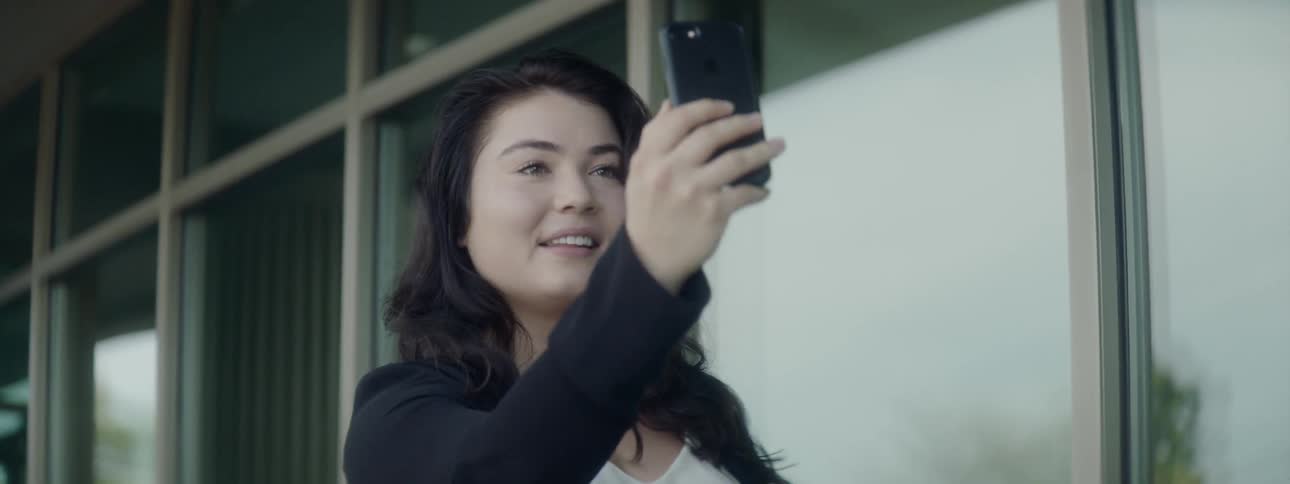 A woman takes a selfie with a camera phone