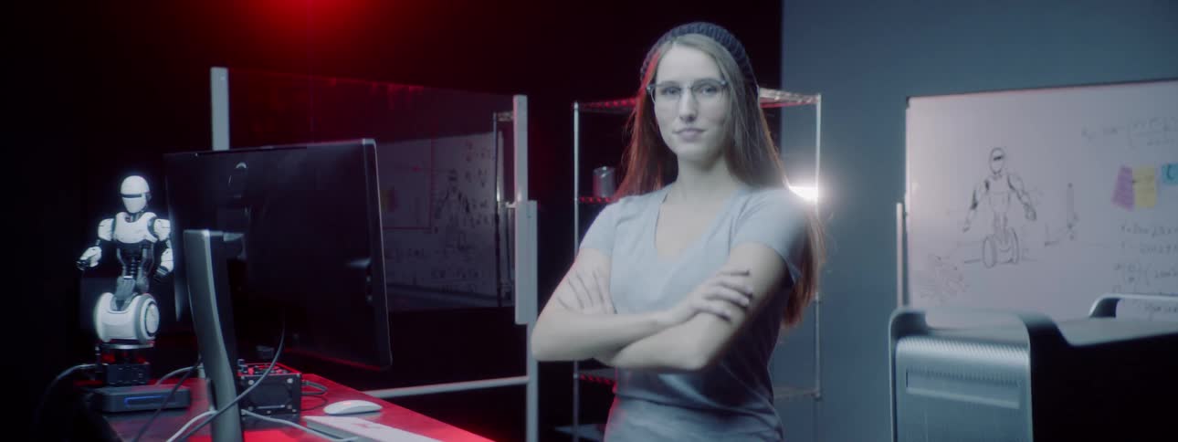 A woman in a robotnik workshop poses