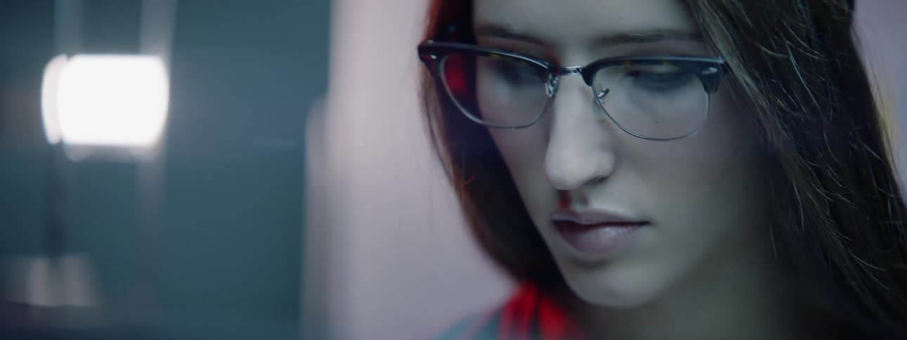 Woman with glasses looks at the camera