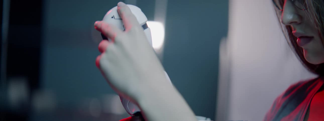 Woman examines a toy robot as she holds it