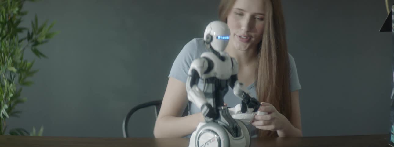 Young woman plays with a remote controlled wheeled robot