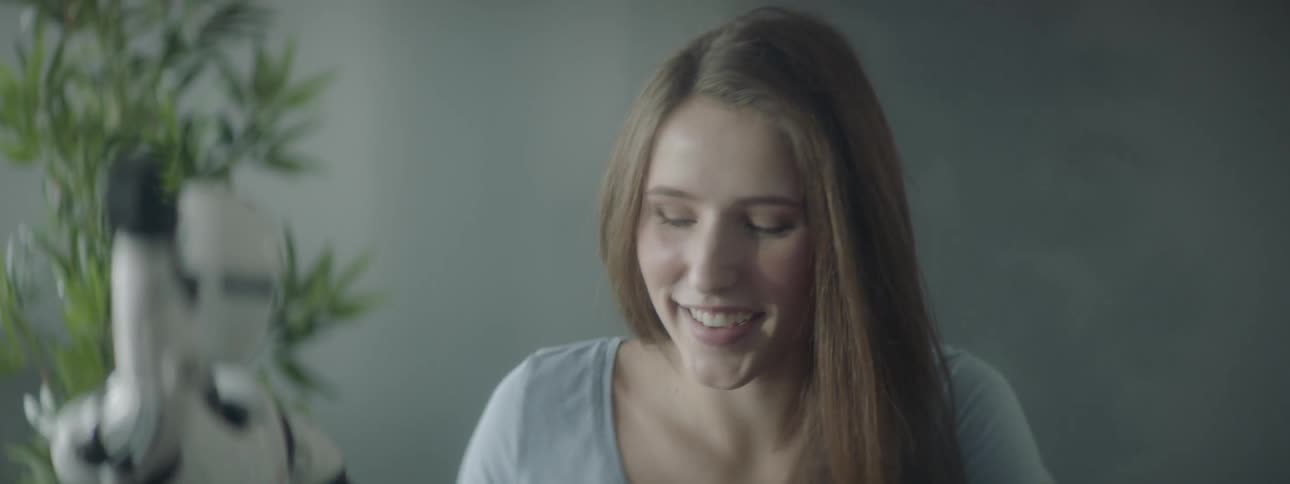 A young girl controls a robot with a remote control