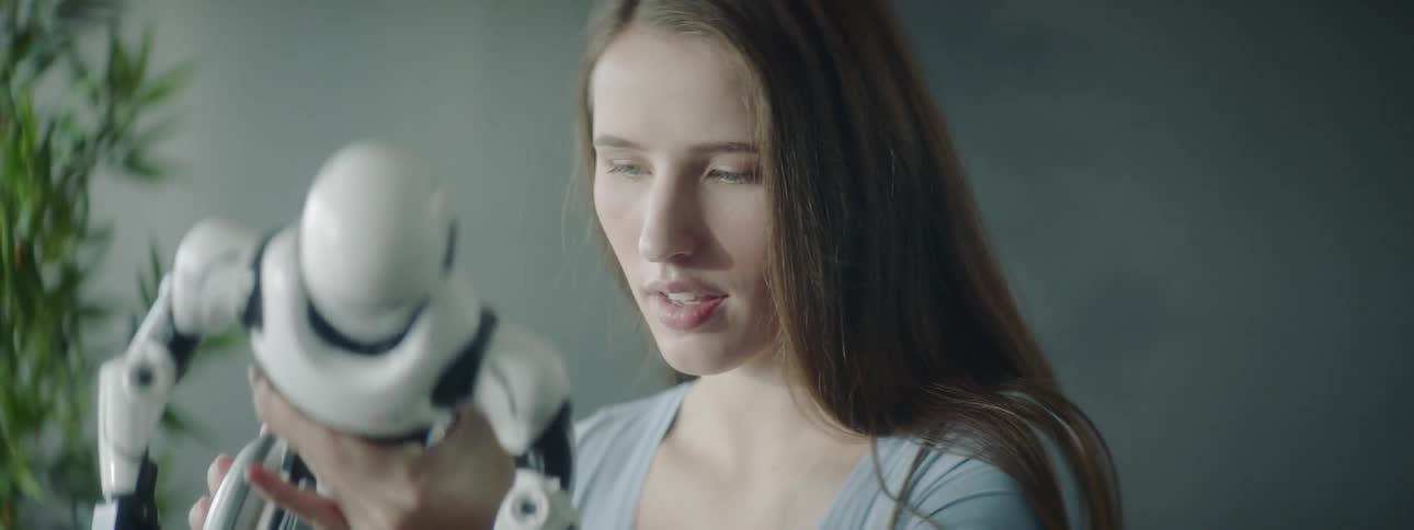 A woman looks over a robot