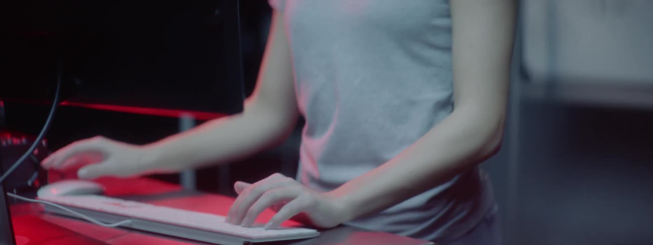 Woman types on a keyboard as she sits at a desk