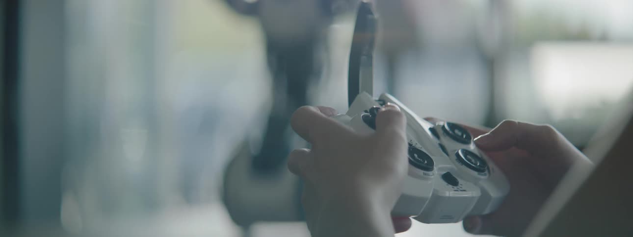A person controlling a toy robot with a radio controller