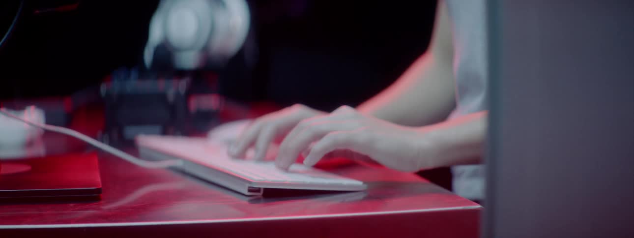 A person types on a keyboard on a desk