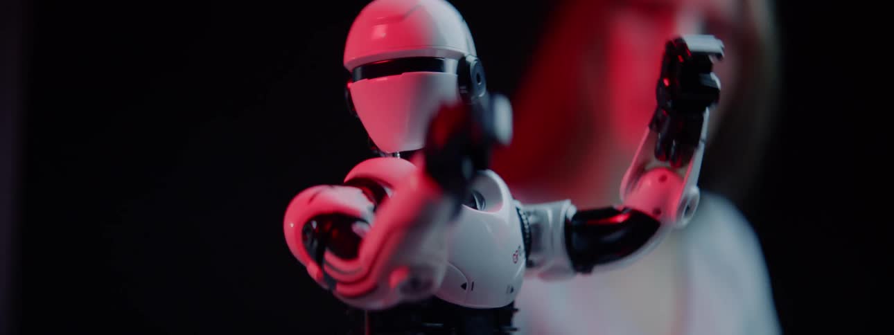 A teenager watches a robot move around