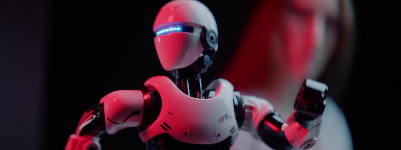 Woman observes small robot as it moves