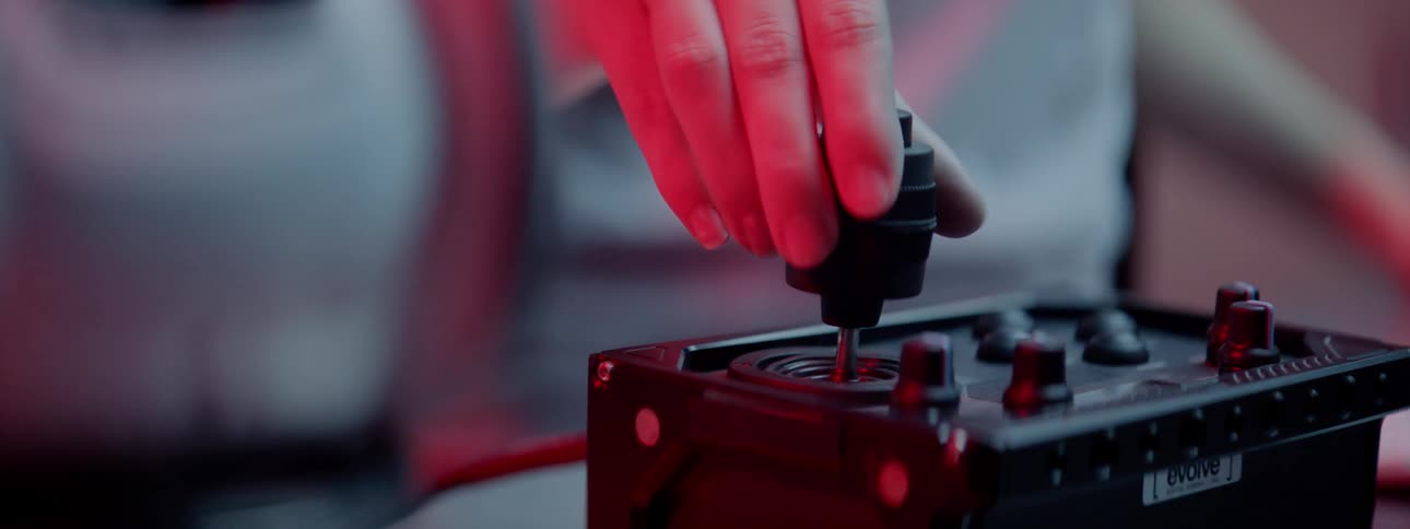 A woman tilts the control stick of a remote control in order to rotate a toy robot