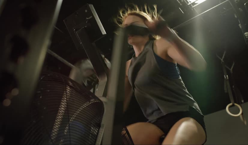 A woman rides a stationary bike in a gym