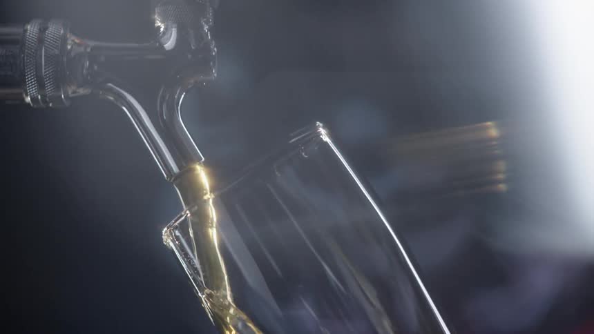 A beer from a tap pouring into a glass