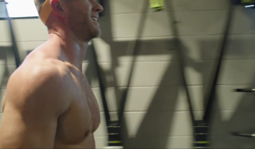 A sweating man drops a sandbag as he completes his workout at the gym and walks away