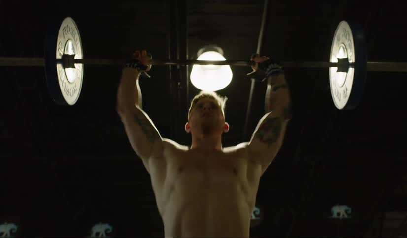 A man lifts a barbell up and drops it down