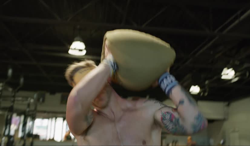 A young man lifts a heavy weight