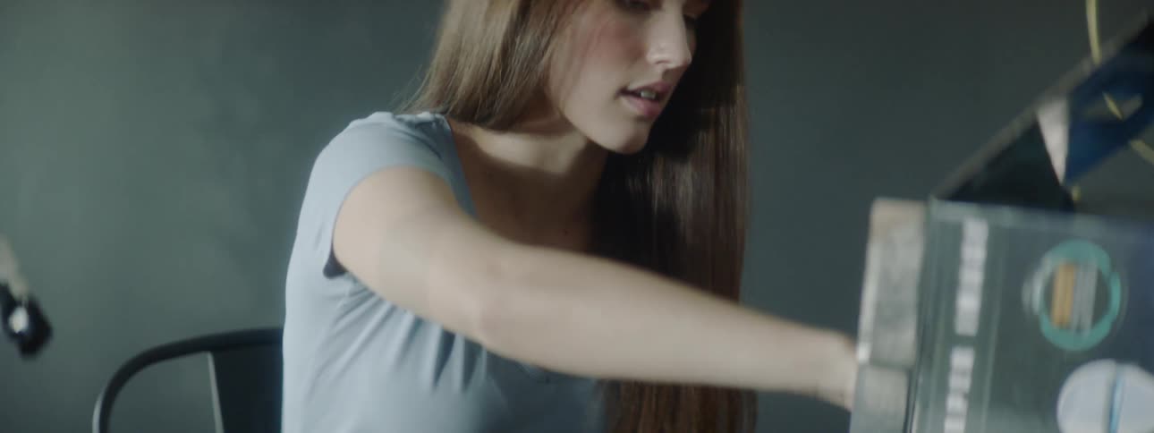 A young girls lifts up a piece of paper and starts to read it
