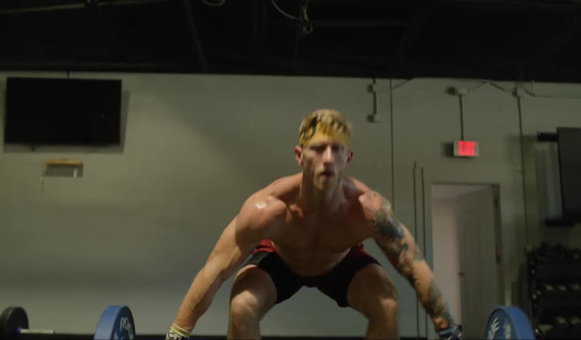 Man lifts weight bar from floor over head