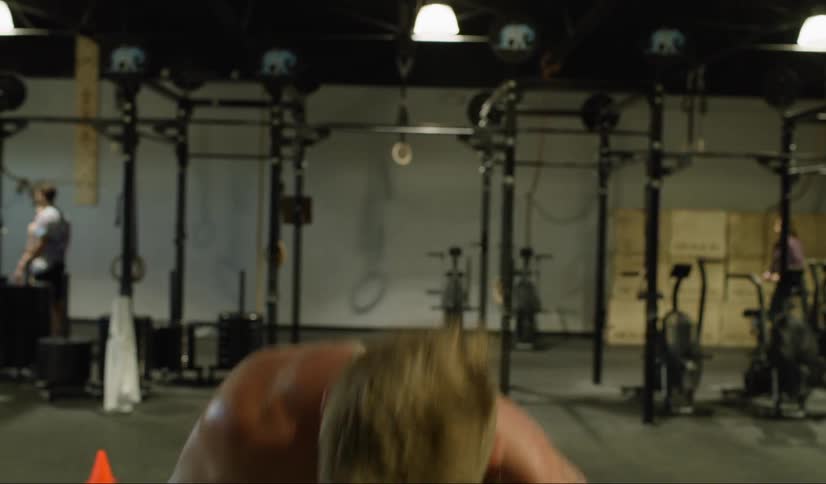 Man in a gym lifts and drops a barbell