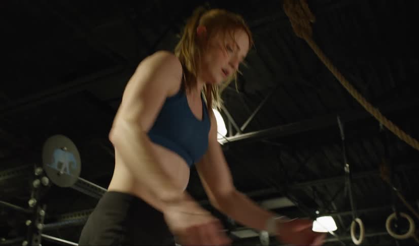 A woman doing box jumps in a gym