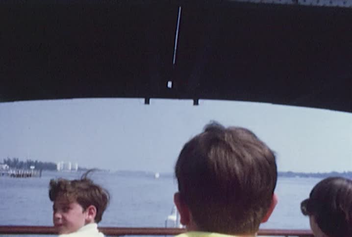 A boat full of people is traveling under a bridge