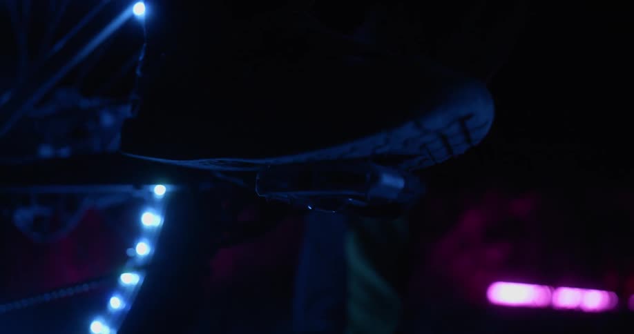 Close up of a shoe spinning a bike pedal at night
