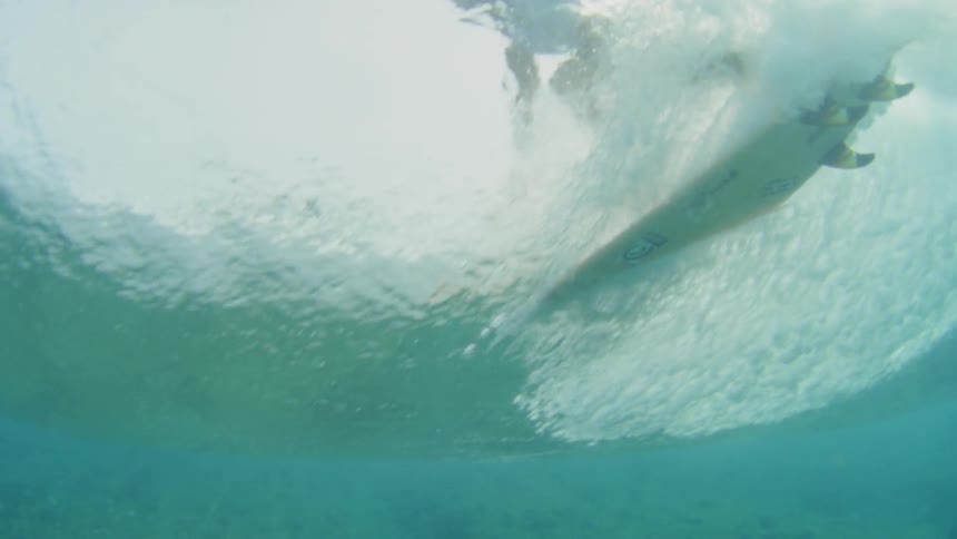 Underwater view of surfer surfing a wave in the ocean