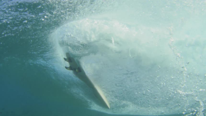 Underwater footage of surfer on surfboard riding wave