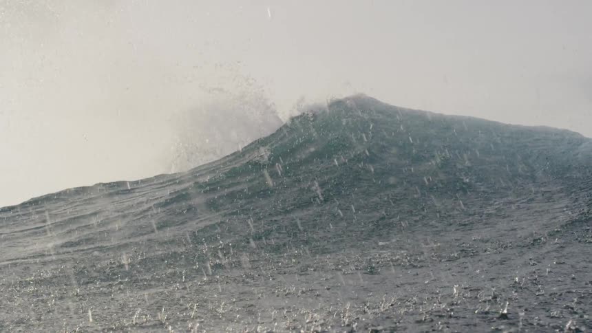 Rain drops splash down on cresting waves then we dip beneath the surface