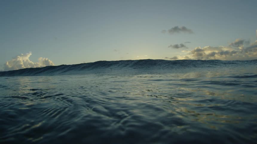 Ocean wave coming closer to the camera at sunset