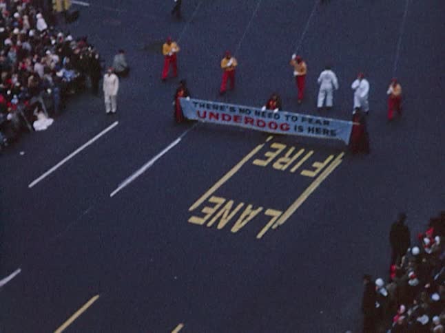Aerial footage of the crowd, a float and an underdog balloon at a parade