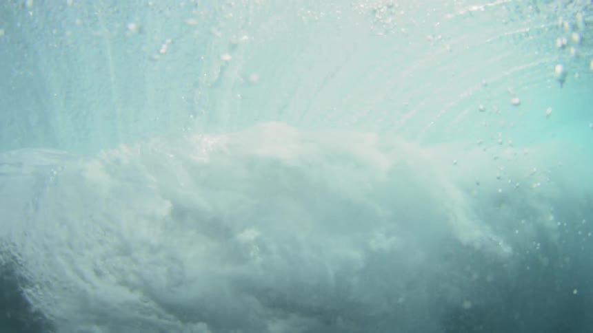 A wave crashing as seen from underwater