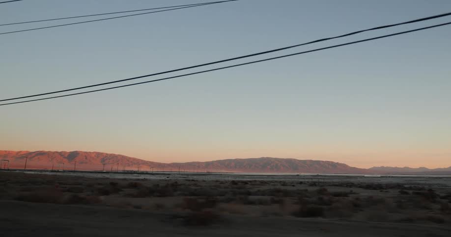 Mountains and power lines pass by the moving vehicle