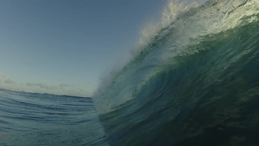 An ocean wave at sunset