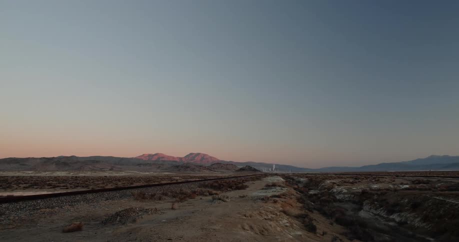 A long stretch of road in the desert at sunset