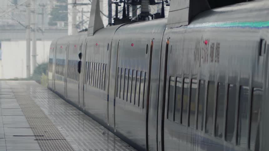 A shadowy figure peeking out from a train car at a train platform