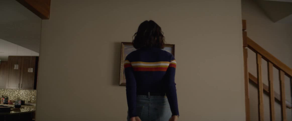 Woman hanging a framed picture on the living room