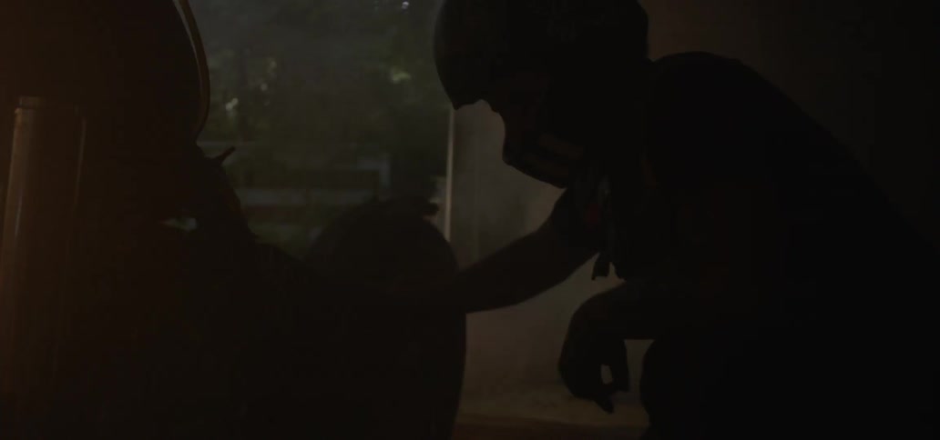 A man in a dark room wearing a helmet works with fire