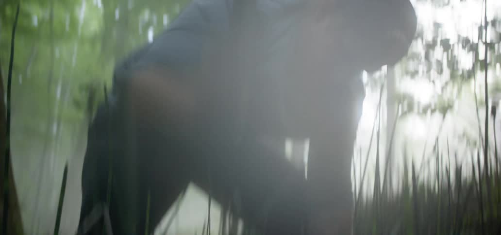 A man uses a machete to cut a tree branch