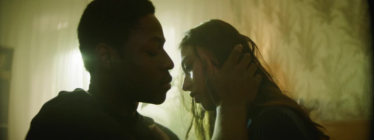 A young man kisses a girl on her forehead