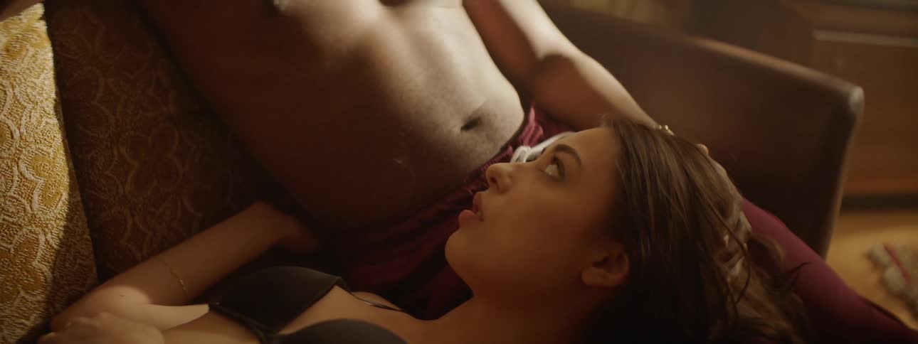 White woman lying at the lap of her boyfriend on the couch while smoking cigarette