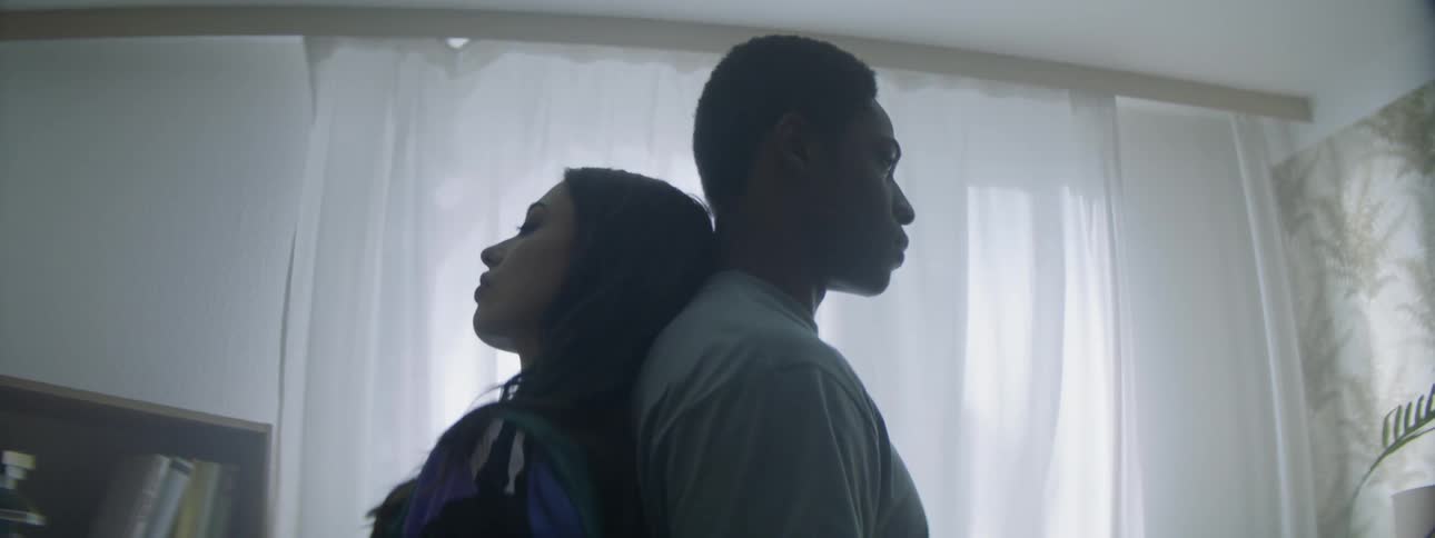 A man and woman stand back to back