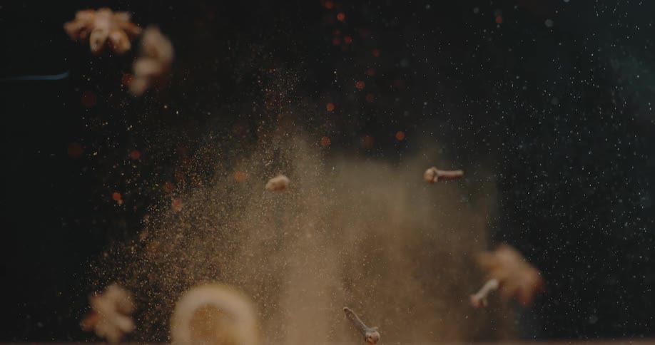 Spices being tossed in the air with fire in the background