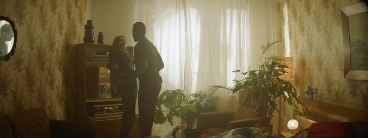 A man and a woman running on the bed and playing in a bedroom