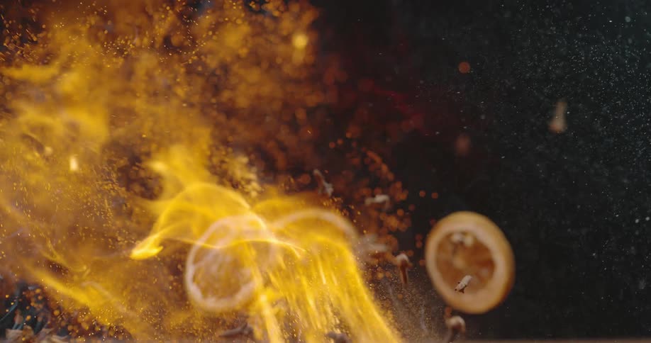 A pile of potpourri is tossed in the air and ignited by a burst of fire and flame