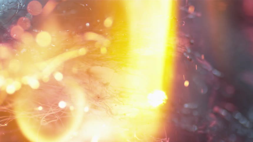 A flame burns a fibrous material that is producing sparks and embers