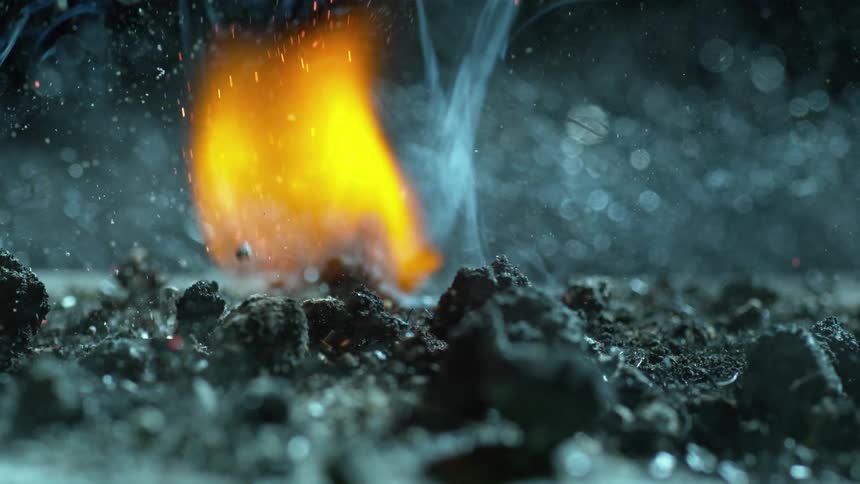 As a flam burns a pile of crumbled charcoal is tossed in the air and the fire grows larger