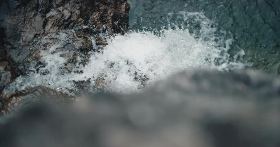 A waterfall landing in a lake below steep cliffs