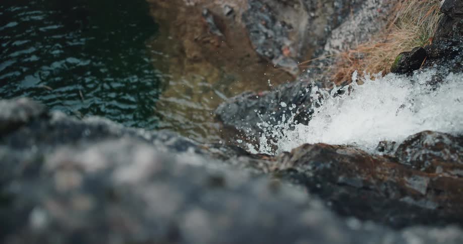 A water fall crashes down a cliff in to the river below